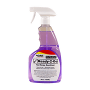 Clear spray bottle with white nozzle on a purple background